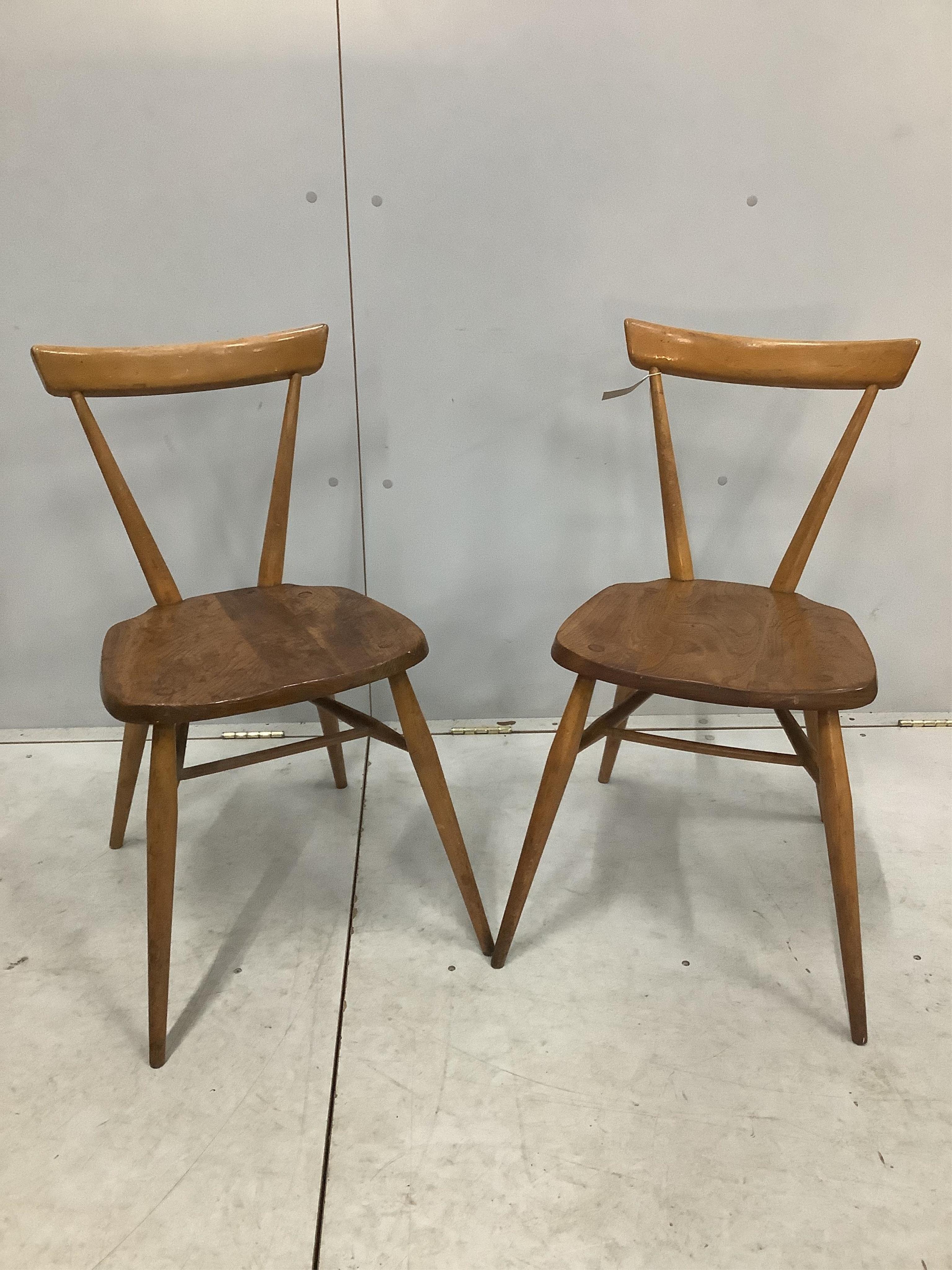 A pair of mid century Ercol elm and beech stacking chairs, width 39cm, depth 35cm, height 76cm. Condition - fair